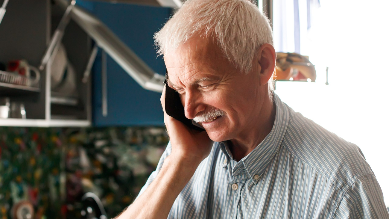 concentrated elderly man with a phone in his hands