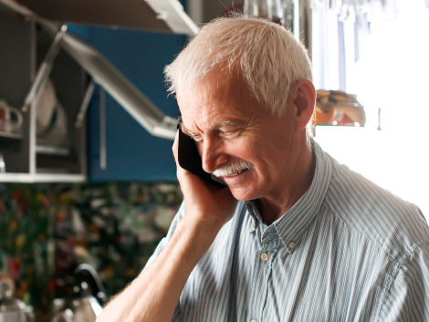 concentrated elderly man with a phone in his hands